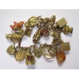 A 9ct gold fine curb-link Bracelet with padlock fastener and numerous charms, approx 70gms all in