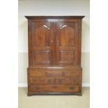An 18th Century oak Court Cupboard with pair of arched fielded panel doors enclosing hanging