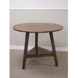 An antique oak Cricket Table with circular top and triangular under tier on chamfered splay legs,