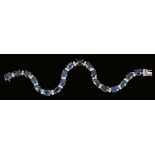 A Sapphire and Diamond Line Bracelet, each articulated link claw-set oval-cut sapphire, total