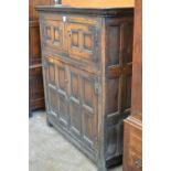 An antique oak panelled Cupboard fitted four doors, mounted on square supports 5ft H x 4ft 6in W