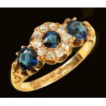 A synthetic Sapphire and Diamond Ring claw-set round sapphire within frame of old-cut diamonds betwe