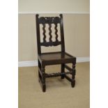 A 17th Century oak Side Chair with floral carved top rail, wavy rail back, solid seat on turned