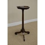 An 18th Century oak Candlestand with octagonal top on turned column and inverted scroll tripod base,