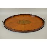 An inlaid satinwood and harewood oval Tray with a shaped rim and carrying handles above a