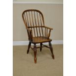 A 19th Century Windsor Elbow Chair with stick back, solid seat on turned legs united by H stretcher
