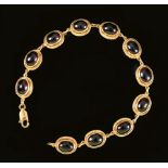 A Garnet Bracelet each link rub over-set oval cabochon in rope twist frame in 9ct gold