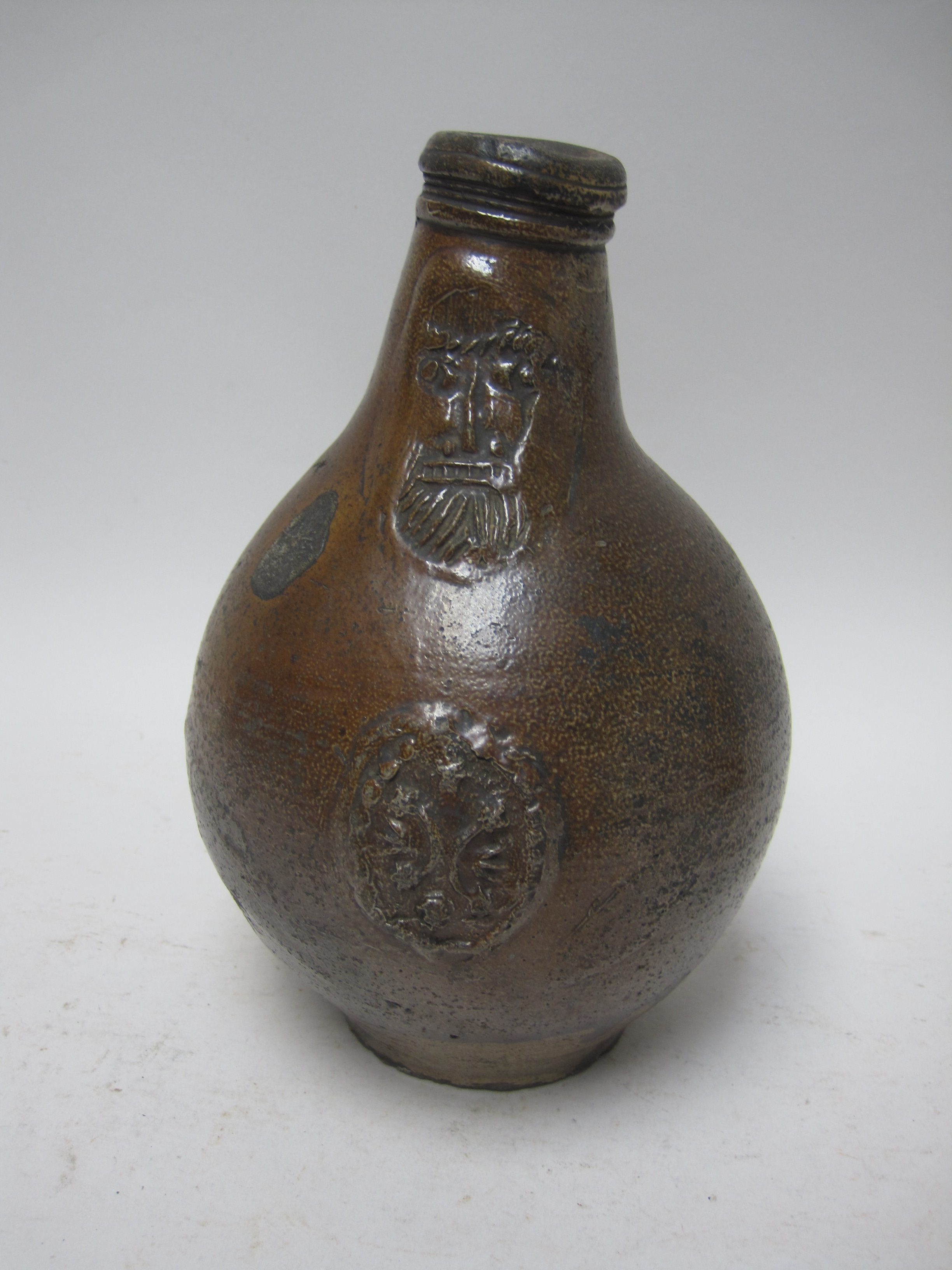 A 17th Bellarmine Flask with mask spout and stylised trident and star cartouche, 8 1/2in