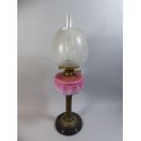 A Victorian Brass Oil Lamp with Opaque Pink Glass Reservoir and Etched Shade,