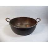 A Large and Heavy Circular Copper Cooking Pot with Two Carrying Handles,