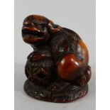 A 19th Century Netsuke. Carved as a Temple Lion and with Black Glass Eyes.