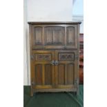 An Oak Old Charm Cocktail Cabinet with Pull Down Linen Fold Top to Mirrored Fitted Interior,