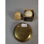 A Circular Brass Golf Ball Sponge together with Two Vintage Golf Balls