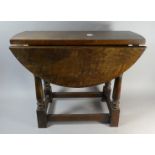 An Oak Circular Topped Drop Leaf Occasional Table on Turned Supports, 60cm Long