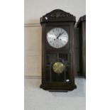 An Edwardian Oak Wall Clock with Glazed Pendulum Box and Brass Mounted Pendulum