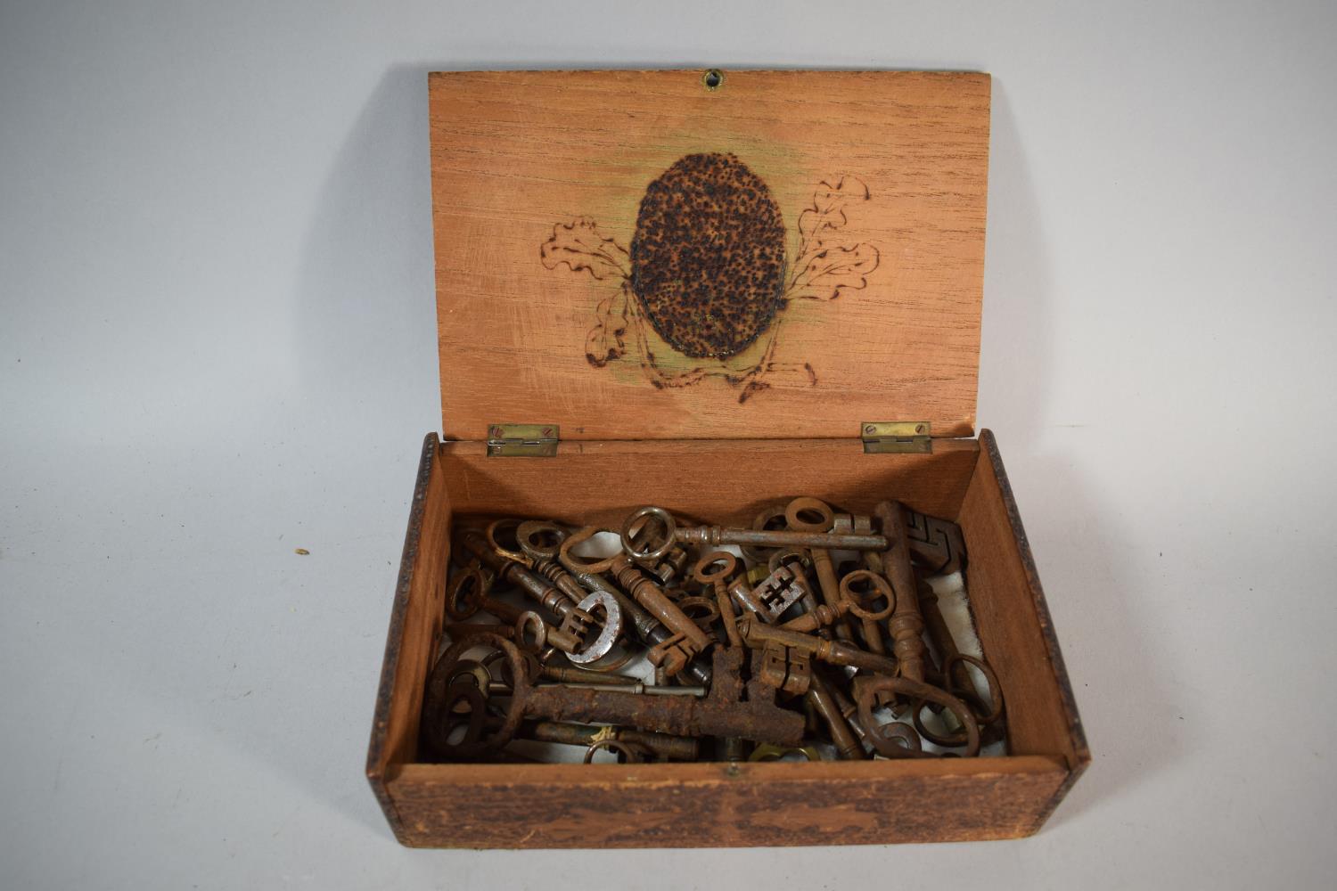 A Poker Work Decorated Cigar Box Containing a Quantity of Vintage Keys