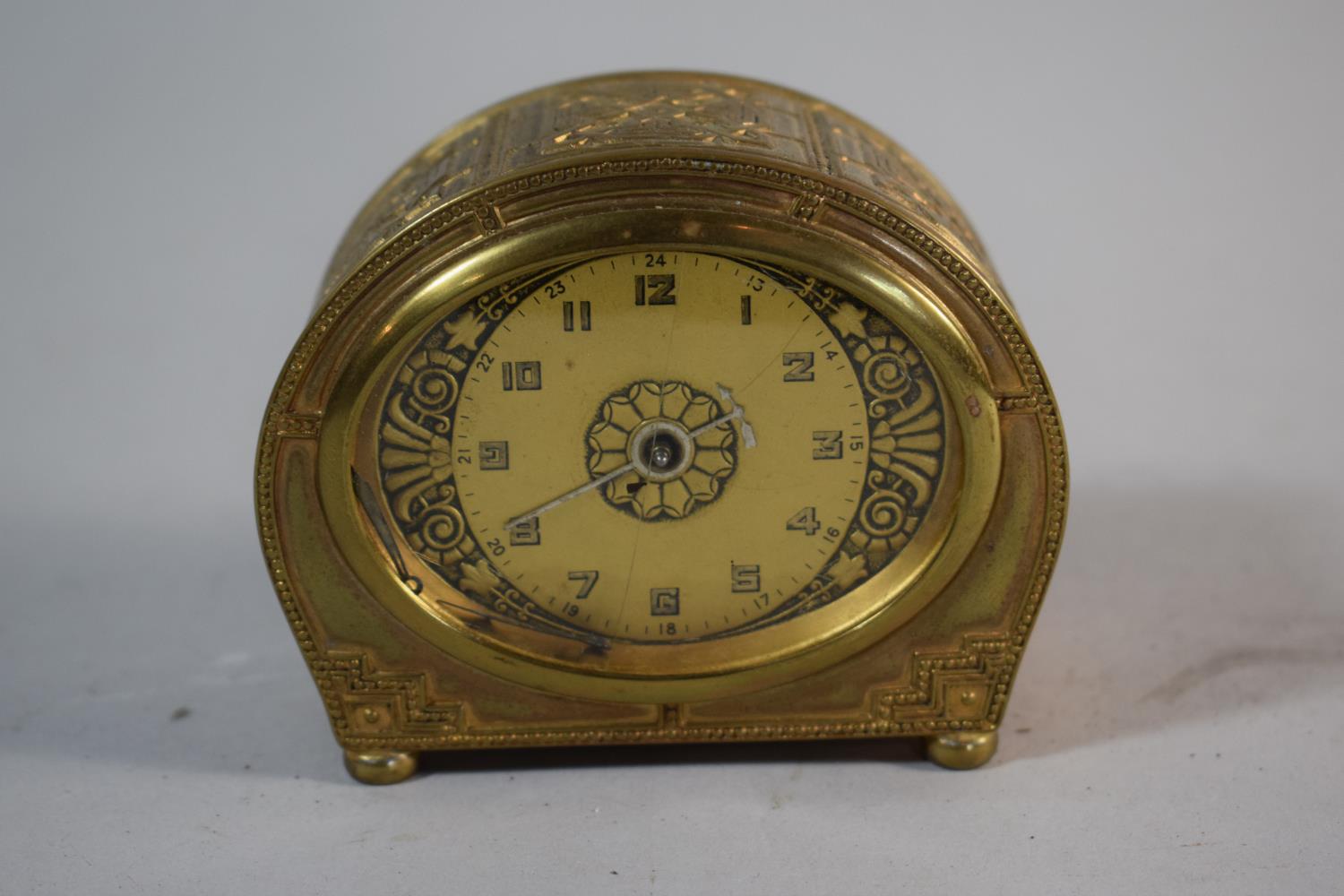 A Mid 20th Century Brass Alarm Clock with Body Decorated in Relief, Fingers Loose, Cracked Glass and