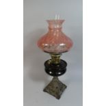 A Late Victorian Iron Based Oil Lamp with Coloured Glass Reservoir and Shade, 56cm high