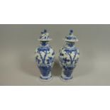 A Pair of Blue and White Lidded Baluster Vases Decorated with Foliate Decoration and Foo Dog