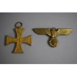 A German Military Merit Cross 'Fur Auszeichnung im Kriege' and a Gilt Nazi Eagle Badge.