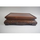 A Good Quality Chinese Hardwood Rectangular Stand with Blind Carved Decoration and Four Scroll Feet.