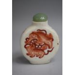 A Chinese Ceramic Snuff Bottle of Flattened Circular Form, decorated with Orange Enamelled Scenes of