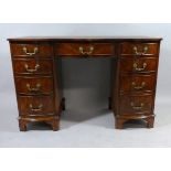 A Pretty Walnut Serpentine Front Kneehole Writing Desk with Centre Drawer Flanked by Two Banks of