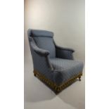 An Edwardian Upholstered Armchair on Brass Castors to Front Legs.