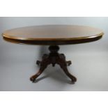 A Late Victorian Mahogany Oval Snap Top Breakfast Table on Four Scrolled Supports. 134x103cms