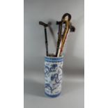 An Oriental Ceramic Cylindrical Stick Stand Decorated with Dragons Containing Six Walking Sticks