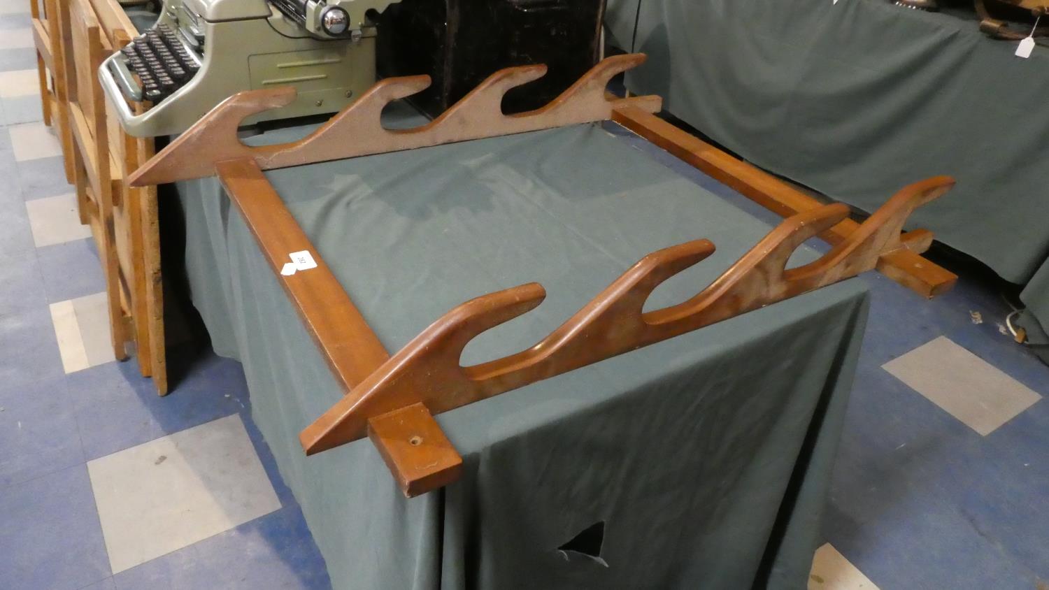 A Wall Hanging Wooden Four Section Gun Rack, 83cm High