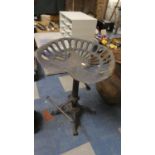 A Reproduction Cast Metal Implement Seat Stool on Quadrant Base