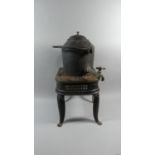 A Black Painted Victorian Iron Footman Together with Cylindrical Kettle with Brass Tap and Loop