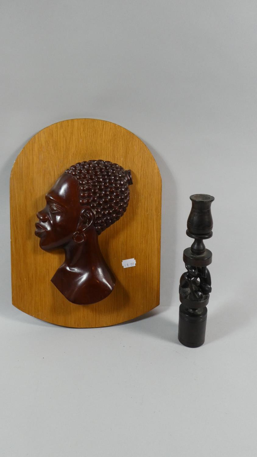 A Carved African Plaque Depicting Maidens Head Together with a Carved African Candle Stick