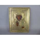 A Russian Orthodox Church Icon of St Nicholas overlaid with a gilt brass repousse riza, approx 18