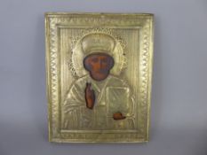 A Russian Orthodox Church Icon of St Nicholas overlaid with a gilt brass repousse riza, approx 18