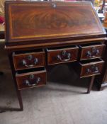 An Antique Figural Mahogany Ladies Bureau, the bureau having a central drawer and kneehole flanked