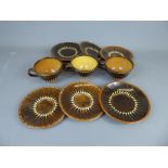 Three Studio Pottery Earthenware breakfast cups and seven saucers, brown with cream slip-trailed