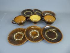 Three Studio Pottery Earthenware breakfast cups and seven saucers, brown with cream slip-trailed