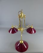 A Pair of Retro Bistro-Style three branch/light brass and cone-shaped red glass pendant ceiling