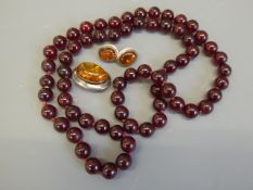 A Set of Dark Red Amber Beads, approx 11 mm, approx 82 cms and 70 gms, together with a pair of