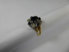 An 18 ct Yellow and White Gold Diamond and Sapphire Ring, the centre sapphire approx 7 x 5 mm,