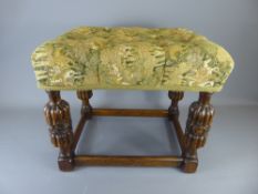 A Victorian Window Seat, with decorative carving to the legs and straight stretchers, green tapestry