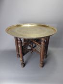 A Brass Topped Moroccan Occasional Table, the folding x-frame support inlaid with mother- of-pearl.