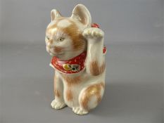 A Japanese Porcelain Maneki Neko (Beckoning Cat).