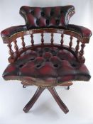 A Burgundy Chesterfield-style Captain's Chair.