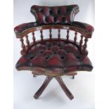 A Burgundy Chesterfield-style Captain's Chair.