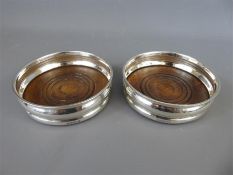 A Pair of Silver and Oak Bottle Coasters