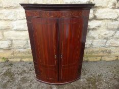 A Georgian Mahogany Bow-Fronted Corner Cupboard