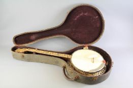 A Vintage Four String Nonpareil Pearloid Tenor Banjo